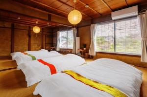 two beds in a room with two windows at 古民家おにぎり in Otsu
