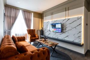 a living room with a couch and a tv on a wall at Kral As Suite Hotel in Istanbul