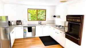 a kitchen with white cabinets and a window at Blue Bay Escape in Venus Bay