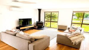 a living room with two couches and a television at Blue Bay Escape in Venus Bay