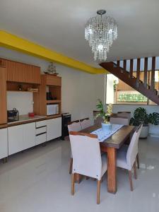 a kitchen with a wooden table and white chairs at Suíte com vista panorâmica in Bombinhas +19 photos