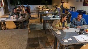 a group of people sitting at tables in a restaurant at Pecém Hotel in Pecém