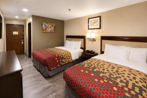 a hotel room with two beds and a kitchen at Economy Inn in Las Cruces