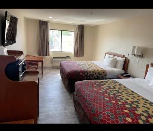 a hotel room with two beds and a television at Economy Inn in Las Cruces +3 photos