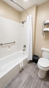 a bathroom with a toilet and a bath tub with a shower at Economy Inn in Las Cruces
