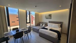 a bedroom with a bed and a table and a desk at Adagio Quito Coliving Ecuador Residences in Quito +205 photos