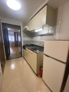 a kitchen with a white refrigerator and a sink at メープル桑園駅311 in Sapporo