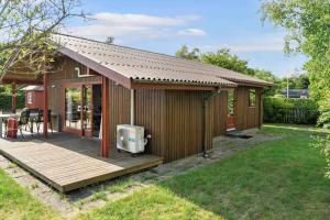 a small house with a deck and a tv at 30306-Odder-Hougaardsvej-6-A in Odder