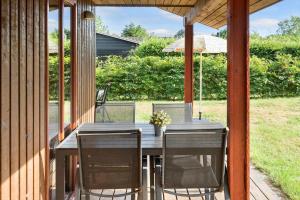 a wooden table with chairs and an umbrella on a porch at 30306-Odder-Hougaardsvej-6-A in Odder