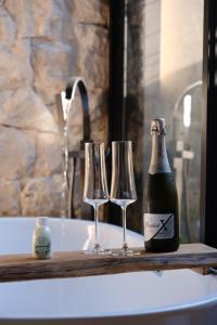 a bottle of champagne and two wine glasses on a bath tub at Rancho Mavi Hospedagem Colônia Witmarsum in Palmeira +23 photos