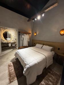 a bedroom with a large white bed and a mirror at Rancho Mavi Hospedagem Colônia Witmarsum in Palmeira