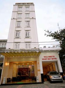 een gebouw waar een auto voor geparkeerd staat bij Night Sky Hotel in Da Nang