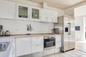 a white kitchen with white cabinets and a refrigerator at 40128-Juelsminde-Strandengen-41 in Juelsminde