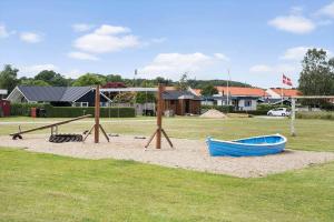 a playground with a blue boat on the sand at 40152-Juelsminde-Mirabellevej-5 in Juelsminde