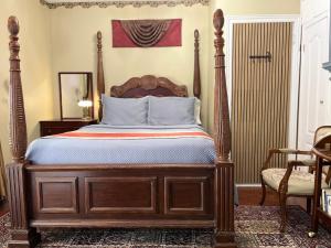 a bedroom with a bed with a wooden frame at Barkerhouse 2# unit-heart of oldtown in Niagara-on-the-Lake