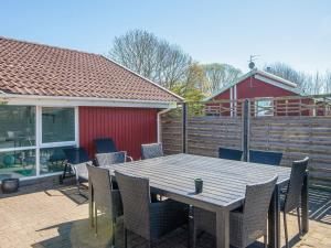 a wooden table and chairs on a patio at 4 star holiday home in Nordborg in Nordborg