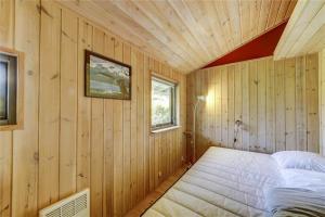 a bedroom with a bed in a wooden wall at 30312-Odder-Lyngbakkevej-29 in Odder