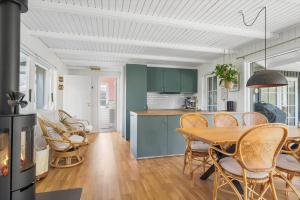 a kitchen and dining room with a table and chairs at 30338-Odder-Skovlunden-11 in Odder