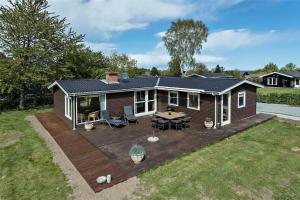 a house with a wooden deck in the yard at 30463-Odder-Solbakken-14 in Odder