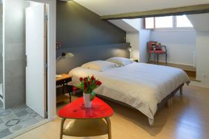 Un dormitorio con una cama y una mesa con flores. en Appartement 9 Place d'Alliance, en Nancy