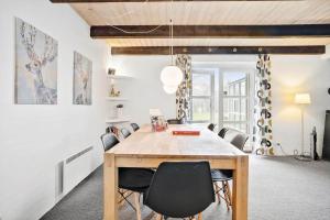 a dining room with a wooden table and chairs at 40154-Juelsminde-Nattergalevej-10 in Juelsminde
