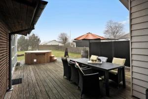 a patio with a table and chairs on a deck at 40154-Juelsminde-Nattergalevej-10 in Juelsminde