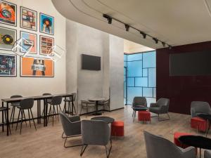a waiting room with chairs and tables and a tv at ibis Dubai Al Rigga in Dubai