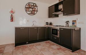 a kitchen with dark brown cabinets and a sink at Kaapstad in Naarden