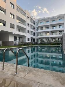 a swimming pool in front of a building at عروس النخيل in Tétouan