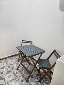 a picnic table and two chairs next to a wall at عروس النخيل in Tétouan +2 photos