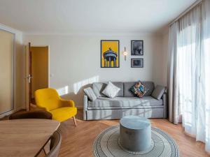 a living room with a couch and a table at Aparthotel Adagio Paris Buttes Chaumont in Paris
