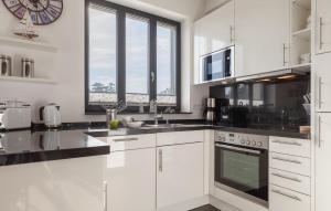 a kitchen with white cabinets and black counter tops at Diamond in Binz
