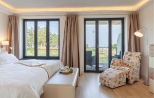 a bedroom with a bed and a chair and a window at Diamond in Binz