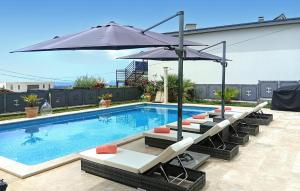 a swimming pool with lounge chairs and an umbrella at Villa Ginocchetti in Kaštelir