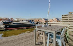 a wooden table and chairs on a dock with a boat at Bob Ross in Naarden