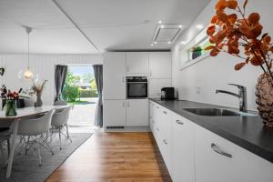 a kitchen with white cabinets and a sink and a table at 30490-Saksild-Praesteager-221 in Saksild +20 photos