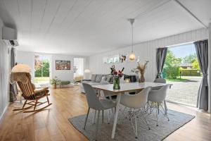 a dining room and living room with a table and chairs at 30490-Saksild-Praesteager-221 in Saksild