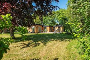 a house in the middle of a field with trees at 30490-Saksild-Praesteager-221 in Saksild