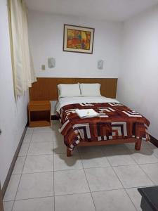 a bedroom with a bed with a blanket on it at hotel esmeralda in Chiclayo