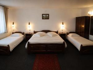 a room with three beds with lights on the wall at Millenium Castle Sibiu - Parking on Site - BIKERS' Haven in the Heart of Romania's Legendary Roads - Rest in Comfort # in Sibiu