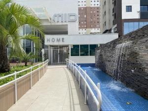 a walkway leading to a home building with a fountain at Lindo studio equipado em apartamento clube com academia e conforto no centro de Curitiba - MID Home in Curitiba