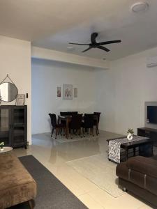 a living room with a table and a ceiling fan at FE Homestay in Tawau