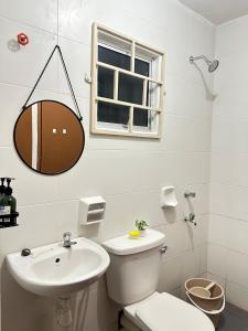 a white bathroom with a toilet and a sink at FE Homestay in Tawau +6 photos