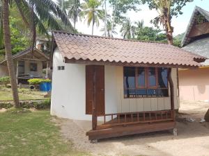 a small house with a brown roof at Diamond Beach Resort in Koh Tao