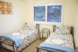 a bedroom with two beds and a window at Jubilee Apartment 14 in South West Rocks +11 photos