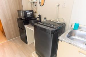 a laundry room with a sink and a microwave at Darin中洲北 2F in Fukuoka