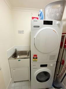 a small kitchen with a washing machine and a sink at Jubilee Apartment 14 in South West Rocks