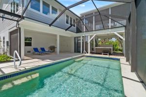a house with a swimming pool and a patio at Seaside Rendezvous in Sanibel