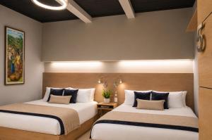 a hotel room with two beds and a lamp at Casa Bella Boutique Hotel in Antigua Guatemala