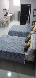 two beds in a room with a kitchen and a table at Apartment Torres in Manuel Antonio